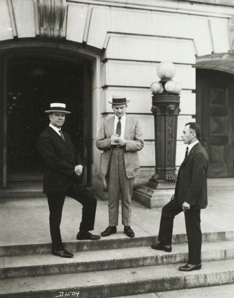 Three men, unidentified, standing on the steps of the Wisconsin state Capitol.