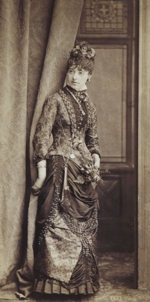 Full-length portrait of Mary C. Gates of Chicago, later Mrs. George Walter Oakley of Madison. From the Hawley and Oakley family collections. G.W. Oakley, 1851-1923, was a nephew of David Atwood of Madison, publisher of the <i>Wisconsin State Journal</i>. He and Miss Gates were married in 1886.