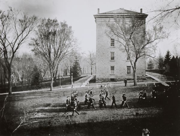 Elevated view across Bascom Hill on the campus of the University of Wisconsin. Student cadets in training march past South Hall down Bascom Hill.