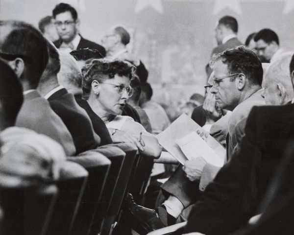 View down row of chairs at the Democratic National Convention showing Mrs. Ethel McMurray of Stevens Point, and Richard McKnight of South Wayne, Wisconsin, both delegates and members of the Platform Committee, in conversation.