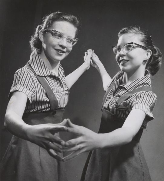 Identical 16-year-old twins Carilynn and Marilynn Powers posed so as to create the illusion of a mirror image.