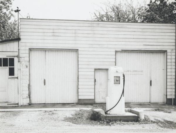Old gasoline pump and garage doors.