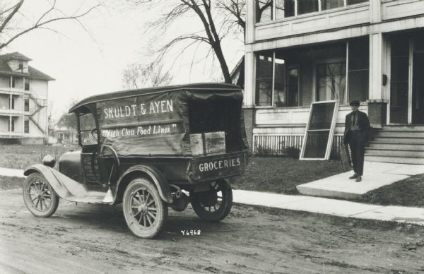 Light delivery truck of Skuldt & Ayen, grocers, in front of a small apartment building.