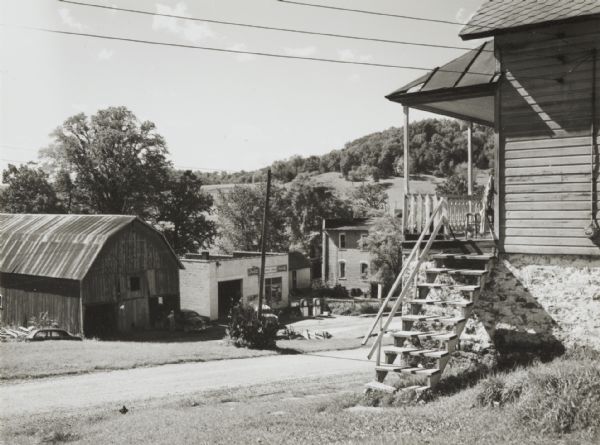 View of a stairway leading up to a second-story residence. Several other commercial and private buildings are visible in the background down a hill.