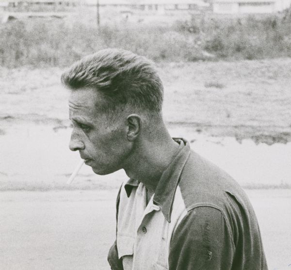 News portrait of Donald A. Buchanan of Minneapolis. Buchanan, then living at the Rescue Mission in Milwaukee, was overcome by gas while he was trying to rescue Forrest McClanahan, apparently from a manhole in the street. He is shown in profile, seated and resting while smoking a cigarette.