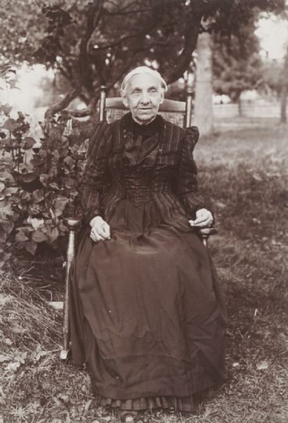 Portrait of Mary Ann Dudley, as an old lady, seated in a garden, Sullivan.