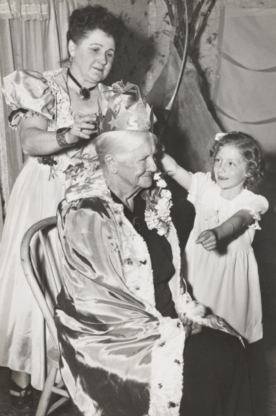 Mrs. Caroline Meyer, 88, being crowned as queen of the day at the centennial program of the Town Mesne Farm Bureau. Mrs. Meyer was honored as the oldest mother in the township.