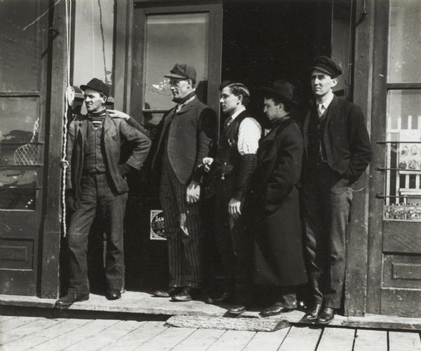Group of railroad employees standing in the doorway of a store.