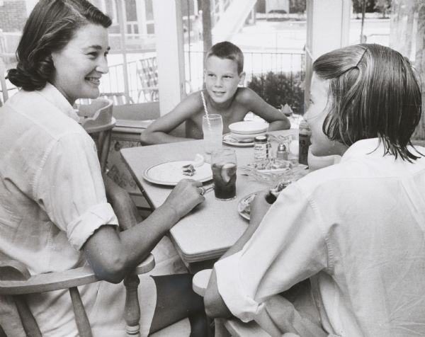 Mrs. Philip G. Kuehn and two of her children lunching at the Town Club (a country club).