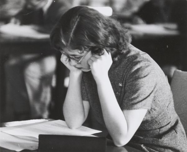 High school student, Judith Castine, leaning on a desk, studying at West Milwaukee High School.