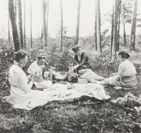 Four women seated as a small picnic party in a wooded area. Jane Ashmun and Harriet Millard are seated on the left. One of Jane Ashmun's daughters is seated on the far right.