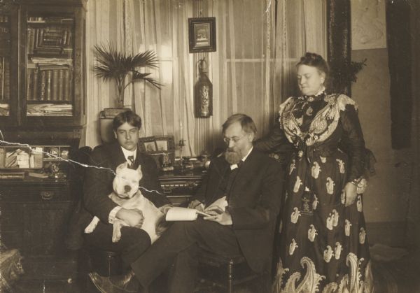 Professor Rasmus B. Anderson, noted authority on Scandinavian affairs, with Karema Anderson and his son Rolf, with dog “Ned”, in their home.