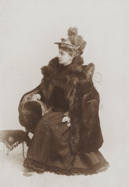 Posed studio portrait of Myrtle Bancroft, dressed in furs. Probably the wife of Levi Bancroft, a prominent figure in Wisconsin politics.
