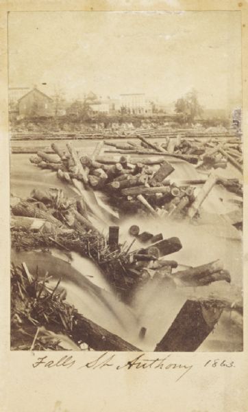 Carte-de-visite view of the Falls of Saint Anthony and logs caught on rocks in the falls.