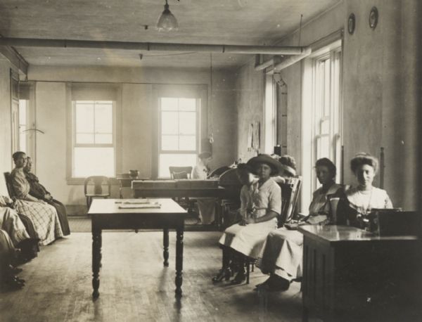 Interior of an office of the Wisconsin State Employment Service, with applicants for work, and officials.