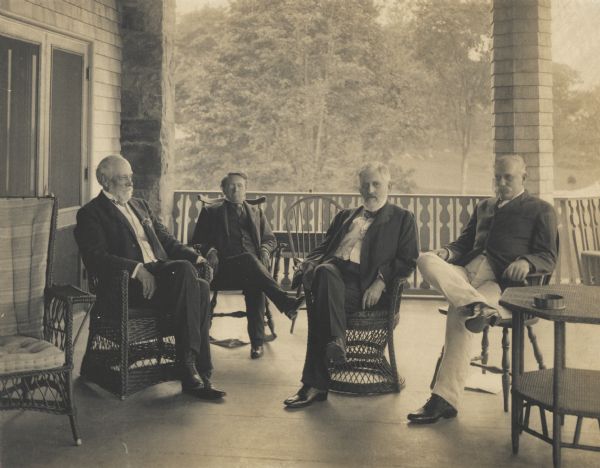 Group of United States Senators seated on the porch of a country estate house. Left to right: Senator Platt, Senator John Coit Spooner of Wisconsin (U.S. Senator in 1885-1891 and 1897-1907), Senator Allison, Senator Aldrich.
