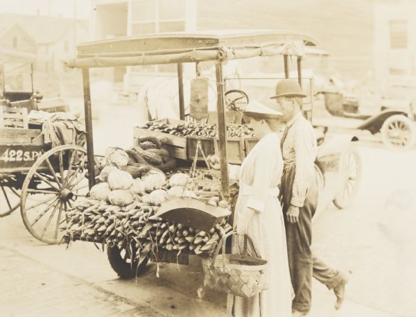 Farm produce for sale from farm trucks at the Municipal Market on the Capitol Square. The Municipal market was established by a committee of women in July, 1917. It began with three producers which increased to thirty. From 100 to 500 consumers patronized the market. 30,000 pounds of rice was sold in two weeks. Market opened in June, 1918.
