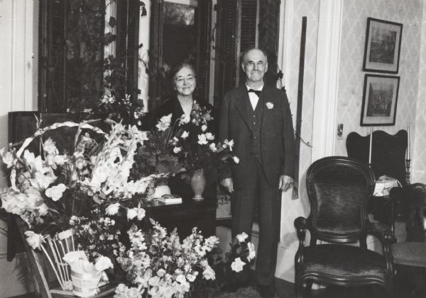 Mr. and Mrs. Sawles stand with floral tributes at their golden wedding anniversary.