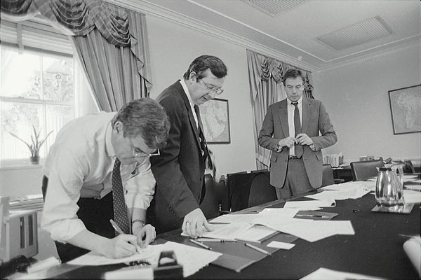 Congressman David R. Obey of Wisconsin (center) and his staff. The conference table is covered with papers and pencils. Framed maps are on the walls.
