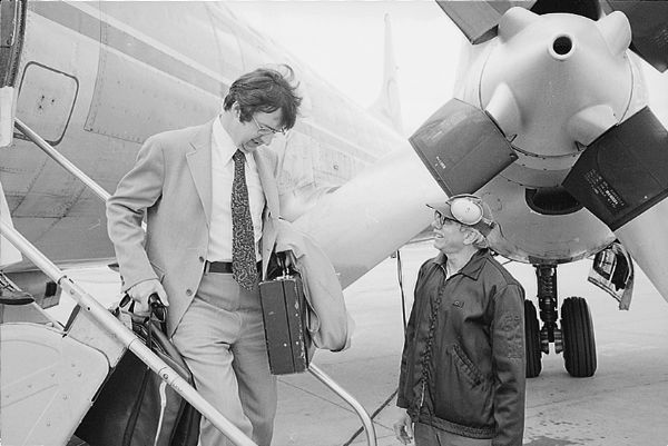 Congressman David R. Obey stepping off a plane for an appointment in his district. An airport employee wearing headphones stands at the foot of the airplane stairs. The airport is unidentified, but it is probably Wausau. The turboprop airplane is owned by Republic Airlines.