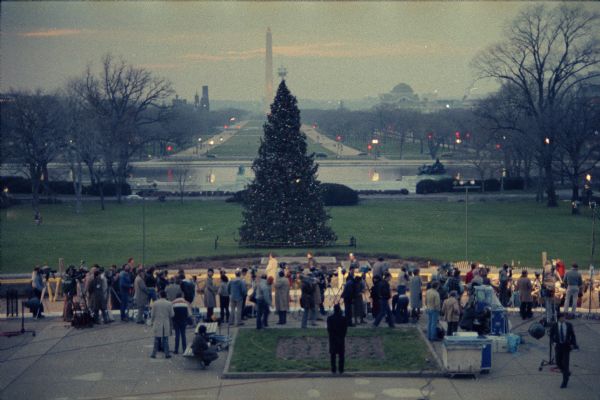 Elevated view of crowd gathered in front of the U.S. Capitol for the lighting of the Capitol Christmas Tree. The tree was cut in the Chequamegon National Forest in Wisconsin. The Washington Monument and other landmarks are visible in the distance.