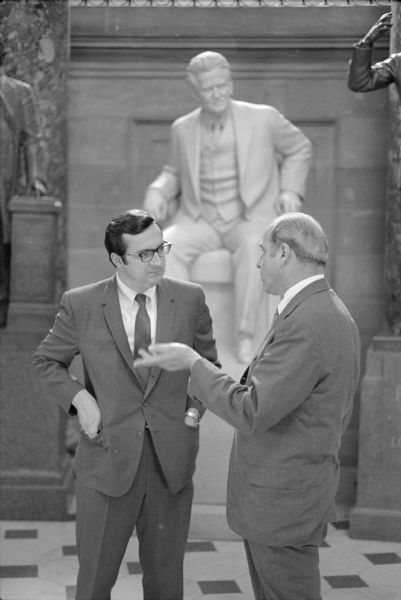 Congressman David R. Obey and Senator Gaylord Nelson posed talking in front of the statue of Robert M. La Follette, Sr. in the National Statuary Hall in the United States Capitol building. The photograph was taken for Obey's first reelection campaign.