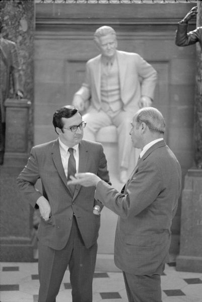 Congressman David R. Obey and Senator Gaylord Nelson posed talking in front of the statue of Robert M. La Follette, Sr. in the National Statuary Hall in the United States Capitol building. The photograph was taken for Obey's first reelection campaign.  
