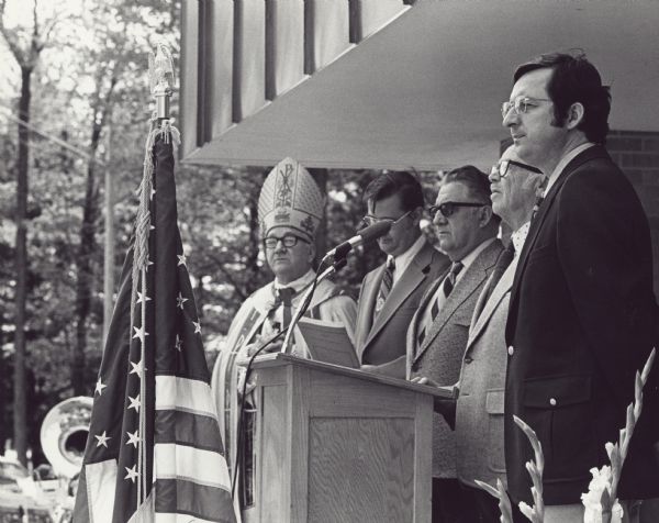 Dedication of an addition to the Holy Cross Hospital. The Catholic order opened Holy Cross Hospital in 1926 and completed this addition in 1974. The hospital was later sold and it became known as the Good Samaritan Health Center. Dignitaries at this event included Bishop Hammes, Pastor Dale Kuck, Mayor Ralph Voight, local businessman
Seidell and Rep. David Obey.
