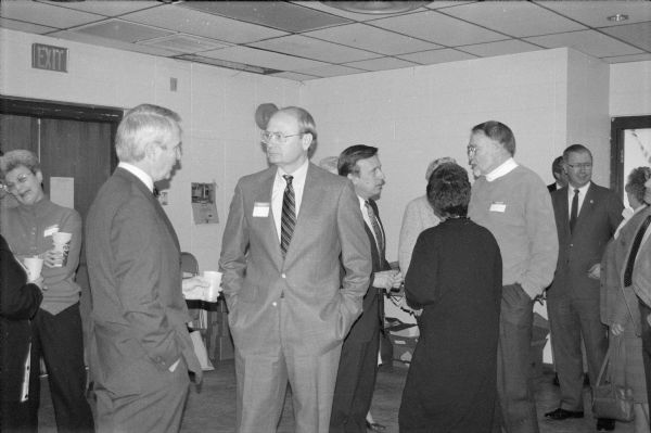 Former Governor Anthony Earl and Assemblyman Thomas Loftus chat at a gathering of statewide Democratic leaders that honored Marlin Schneider. President Clinton later appointed Loftus ambassador to Norway.