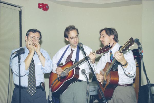 Congressman David Obey (playing the harmonica) of Wisconsin with his two sons, Douglas and Craig, performing as part of the Capital Offenses, a bluegrass band formed by Obey.