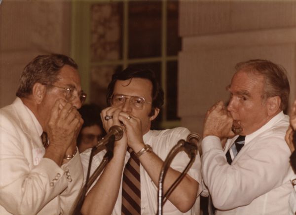 Wisconsin Congressman David R. Obey (center), playing the harmonica with Speaker of the House Jim Wright (right), and Congressman Jake Pickle (left).