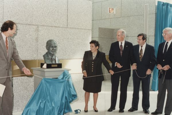 Donna Shalala, Secretary of Health and Human Services and former Chancellor of the University of Wisconsin-Madison, unveils a bust of Congressman William H. Natcher at the dedication of the National Institute of Health's Natcher Building in 1994. Second from the right is Congressman David R. Obey of Wisconsin, who succeeded Natcher as chairman of the Appropriations Committee.