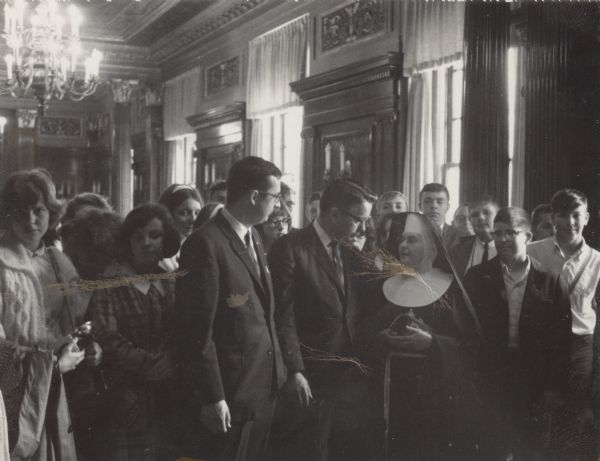 Assemblyman David R. Obey and Patrick J. Lucey meeting with a group of students and their teacher, a nun, in the Wisconsin Assembly Parlor.  Although undated, the picture was probably taken between 1965 and 1966 when Lucey was the Lieutenant Governor.
