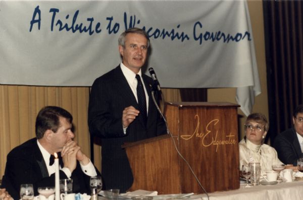 Governor Anthony Earl speaking at a political tribute taking place at the Edgewater Hotel.