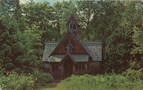 Color postcard view of a privately built chapel, decorated in Norwegian style by Mr. and Mrs. Boynton, surrounded by trees.