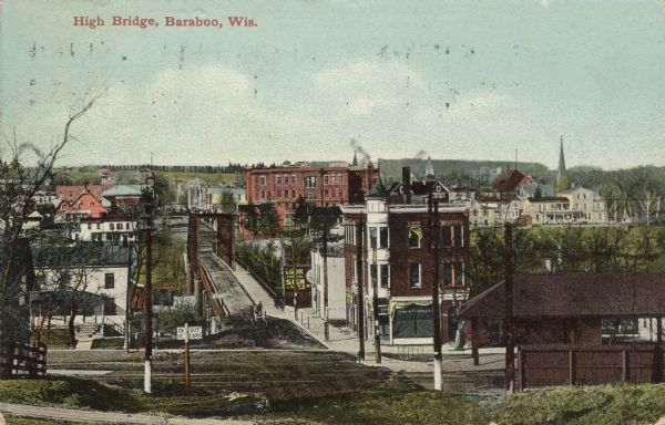 Colorized photographic postcard of an elevated view of central Baraboo from across the railroad tracks. Caption reads: "High Bridge, Baraboo, Wis."