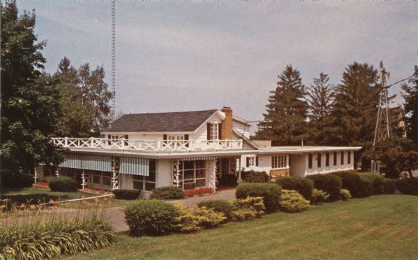 Exterior view of The Farm Kitchen — a motel and restaurant. Bushes and flowers are planted along the drive.