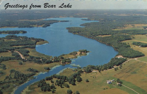 Aerial view of Bear Lake, with surrounding forests and farms. Caption reads: "Greetings from Bear Lake."