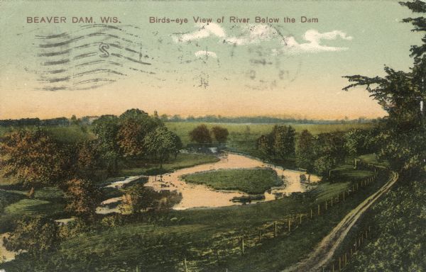 Colorized postcard of an elevated view of a river with a dam in the distance. Caption reads: "Beaver Dam, Wis. Birds-eye View of River Below the Dam."