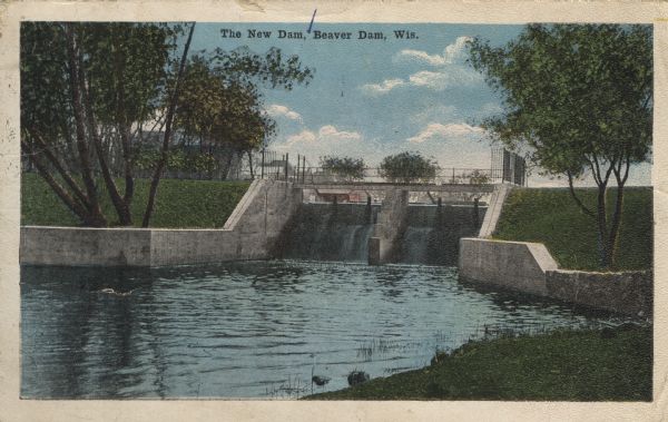 Colorized postcard view of a dam on a river. There is a factory behind the trees in the background. Caption reads: "The New Dam, Beaver Dam, Wis."