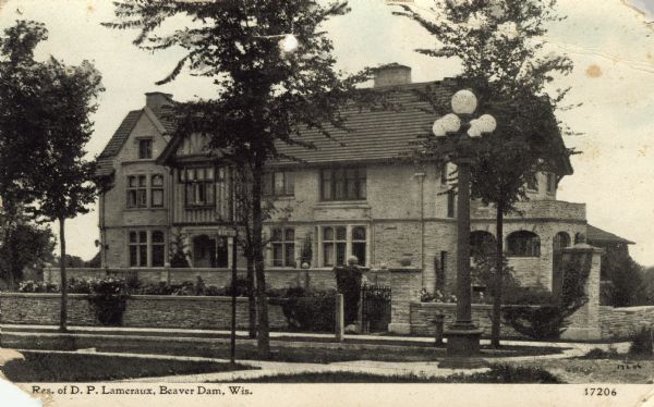 Photographic postcard view of a stone mansion surrounded by a stone fence. Caption reads: "Residence of D.P. Lameraux, Beaver Dam, Wis."
