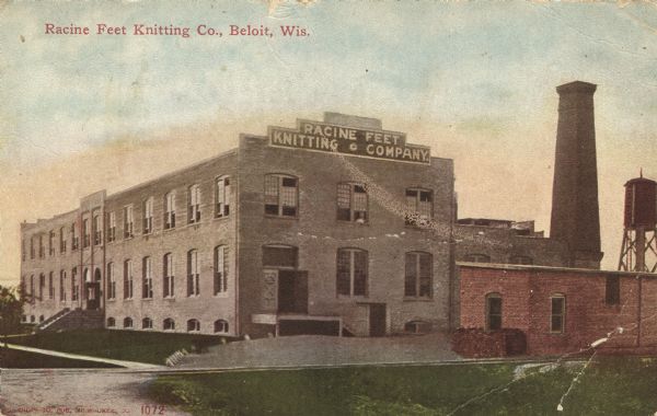 Colorized postcard view of a textile factory with large windows and a loading dock on the side. Caption reads: "Racine Feet Knitting Company, Beloit, Wis."