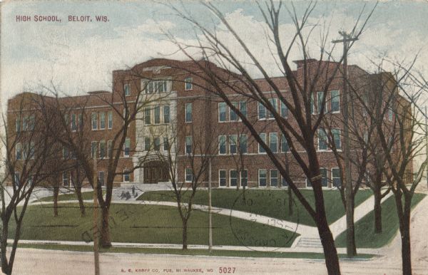 Colorized postcard of the exterior view of a high school. Students are sitting on the front steps. Caption reads: "High School, Beloit, Wis."