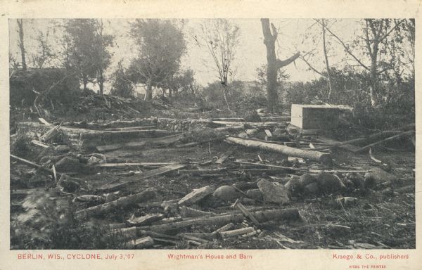 Photographic postcard view of the aftermath of a tornado that destroyed a farm. Caption reads: "Berlin Wis., Cyclone, July 3, '07 — Wightman's House and Barn."