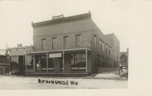 Photographic postcard of an exterior view from street of a hotel on a snowy day. Caption reads: "Birnamwood, Wis."
