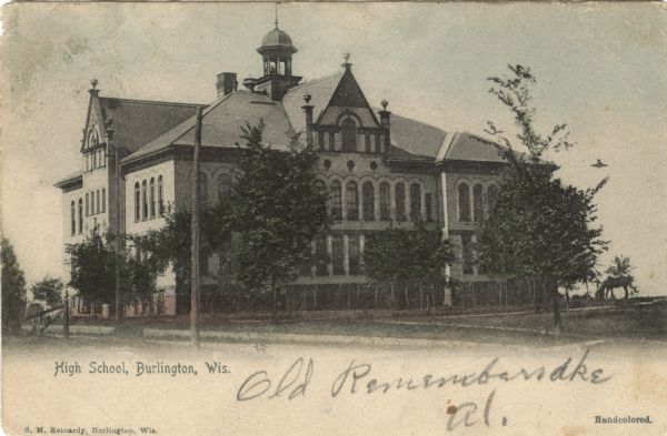 Hand-colored view of the exterior of a high school. A horse is grazing in the yard on the right. Caption reads: "High School, Burlington, Wis."