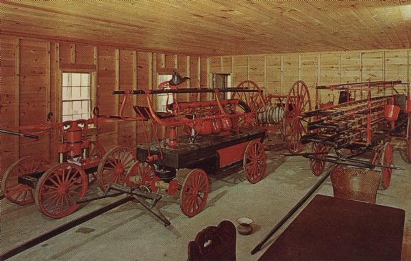 Color postcard of the Firehouse interior at Stonefield. The jail is through the rear door on the left.