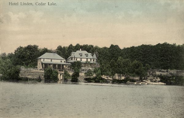 Hand-colored view across water towards the Hotel Linden on the shore of Cedar Lake. On the far shoreline are two buildings, a boathouse, and boats lined up along the shoreline on the beach. Caption reads: "Hotel Linden, Cedar Lake."