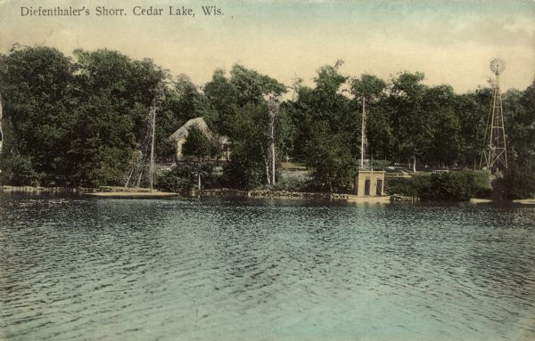 Hand-colored view of Diefenthaler's Shorr Resort at Cedar Lake. The view across the lake is of buildings behind trees, a sailboat at the dock, a rowboat at the landing, and a windmill on the right. Caption reads: "Diefenthaler's Shorr, Cedar Lake, Wis."