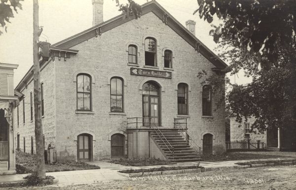 Photographic postcard view of Turn Halle, a three-story stone building. Caption reads: "Turn Halle, Cedarburg, Wis."